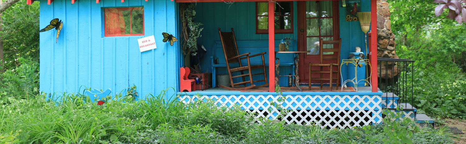 A porch with a rocking chair and table.