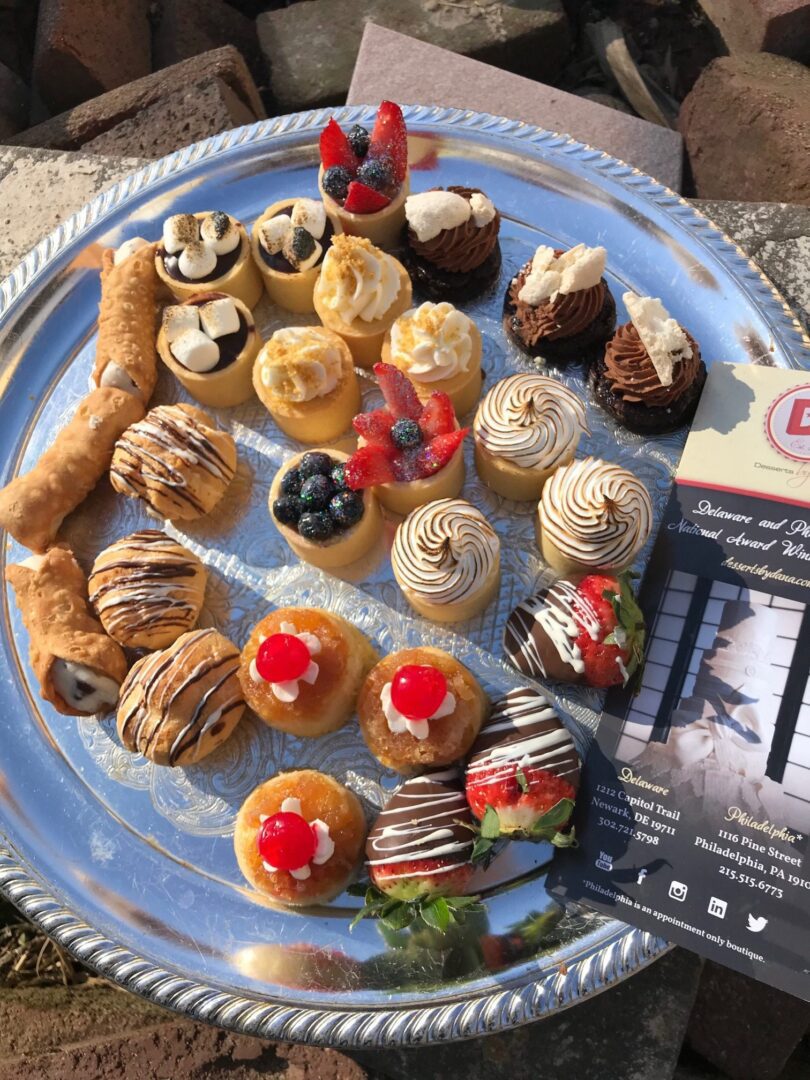 A plate of pastries and cupcakes on the table