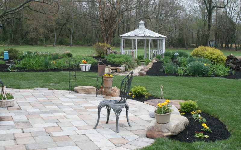 A garden with a gazebo and many flowers