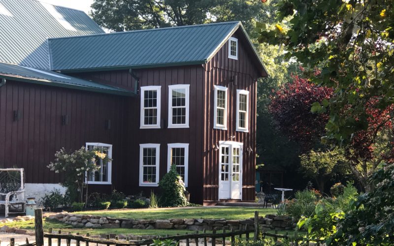 A large brown house with green roof and white door.