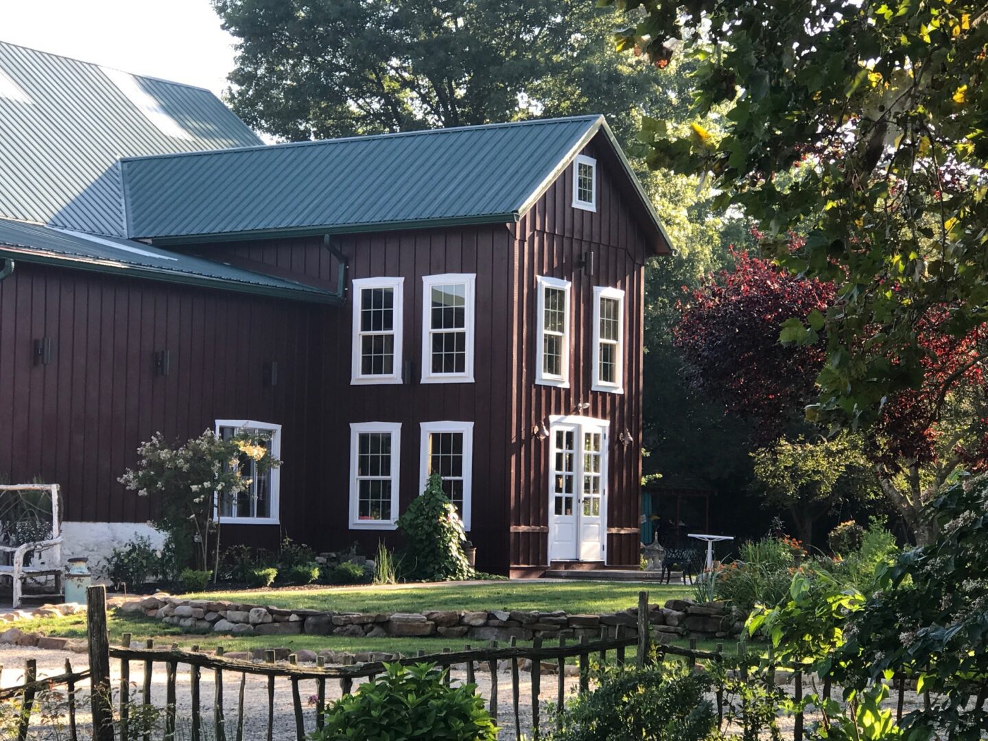 A large brown house with green roof and white door.