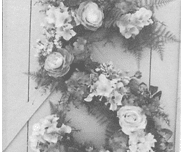 A black and white photo of flowers on the front of a door.