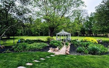 A gazebo in the middle of a garden.