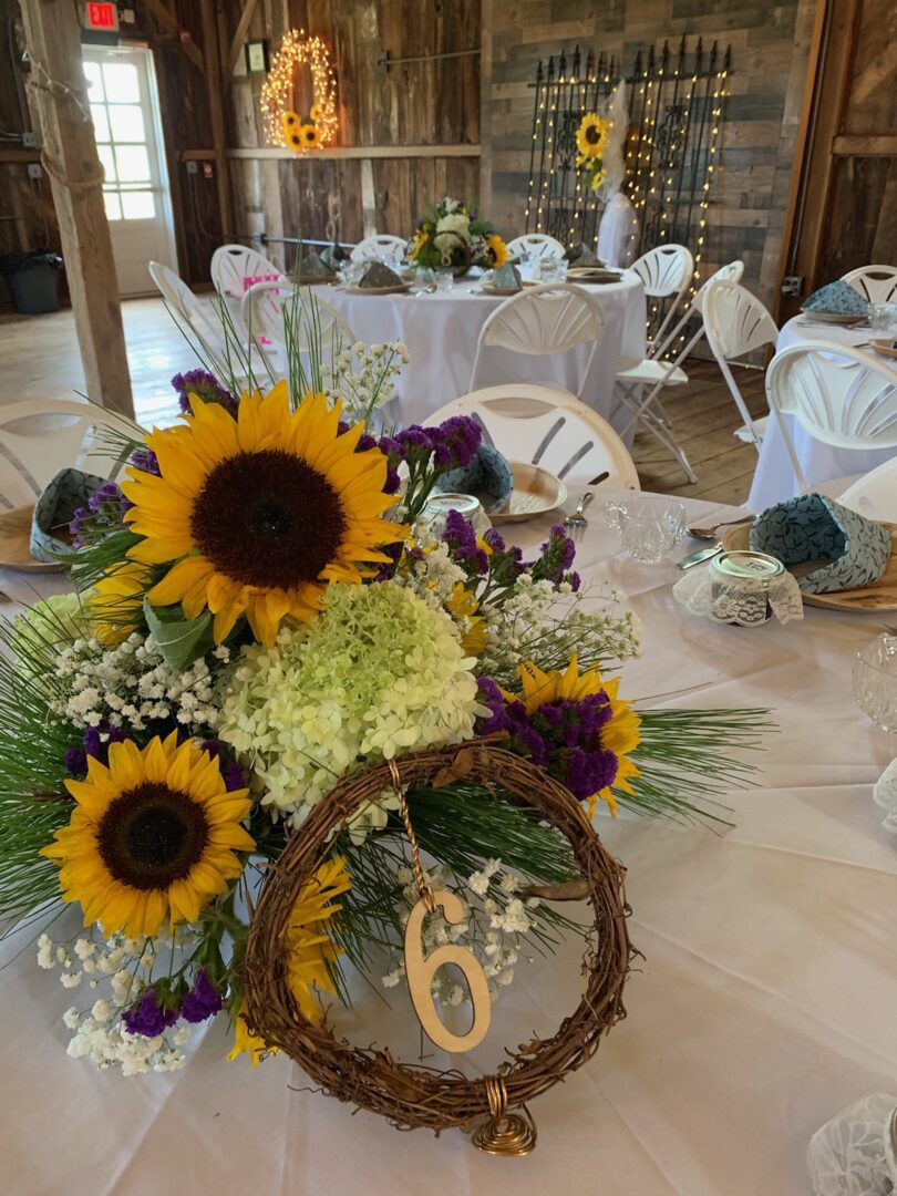 A table with sunflowers and other flowers in it.