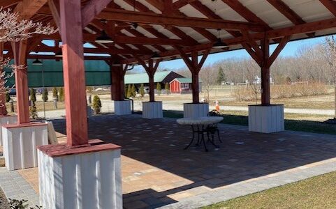 A large pavilion with tables and benches in it.