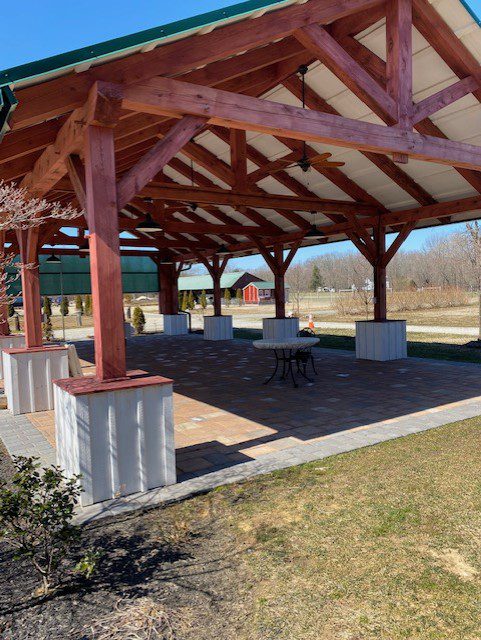 A large pavilion with tables and benches in it.