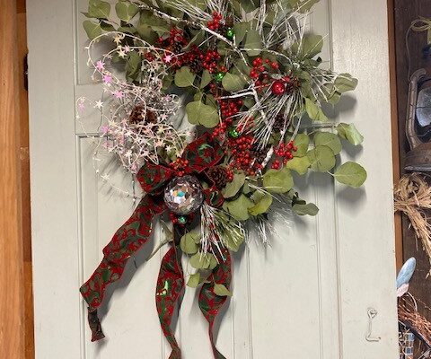 A door with a wreath hanging on the side of it.