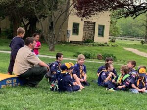 A group of scouts sitting on the grass