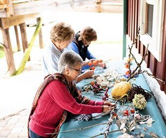 Three women are sitting at a table with decorations.