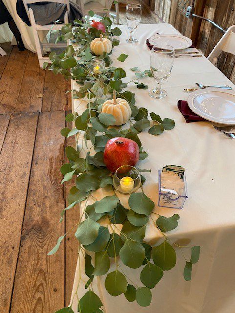 A table with candles and greenery on it