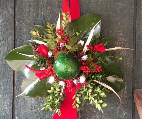 A green apple and red ribbon hanging on the wall.