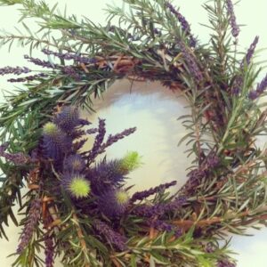 A wreath of green and purple flowers on the wall.